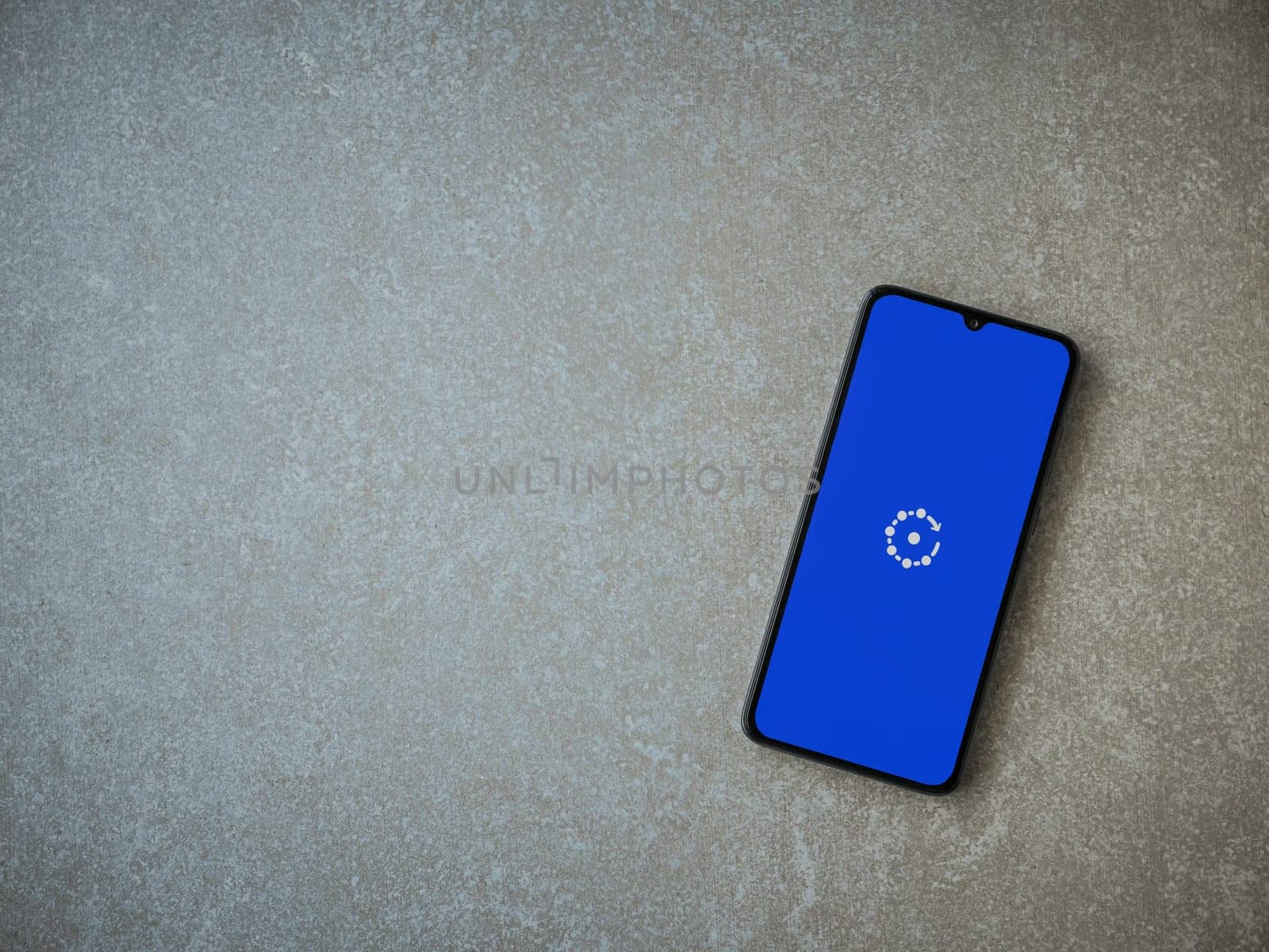 Lod, Israel - July 16,2023: Fing app launch screen on smartphone on ceramic stone background. Top view flat lay with copy space.