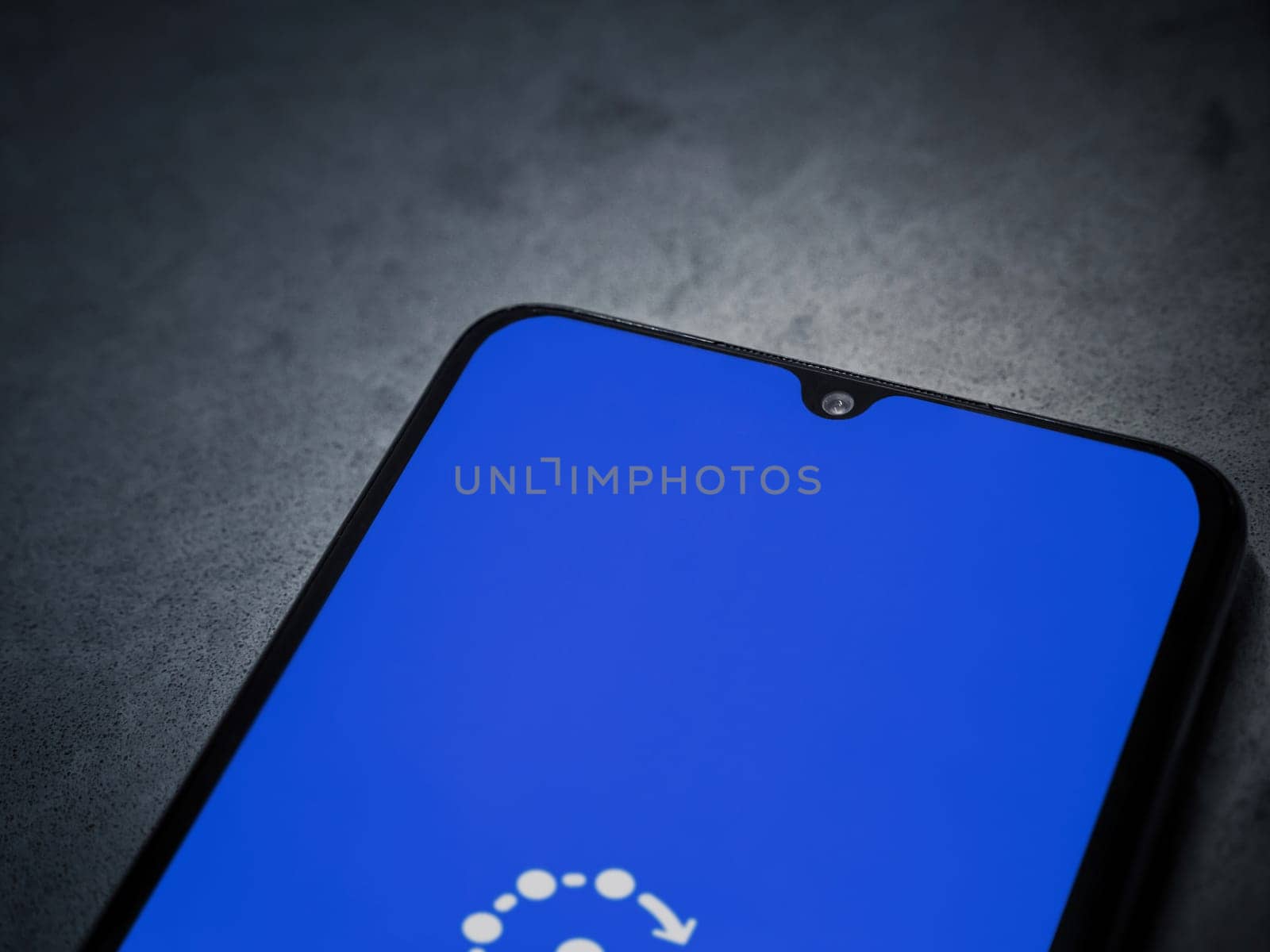 Lod, Israel - July 16,2023: Fing app launch screen on smartphone on dark marble stone background. Top view flat lay with copy space.