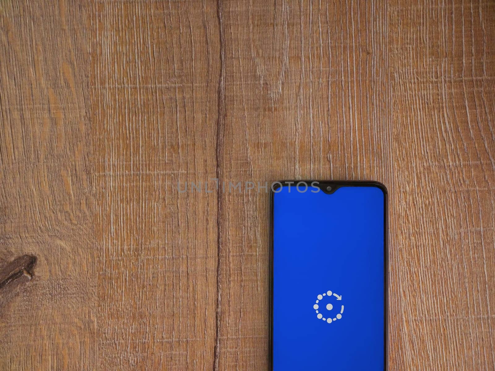 Lod, Israel - July 16,2023: Fing app launch screen on smartphone on wooden background. Top view flat lay with copy space.