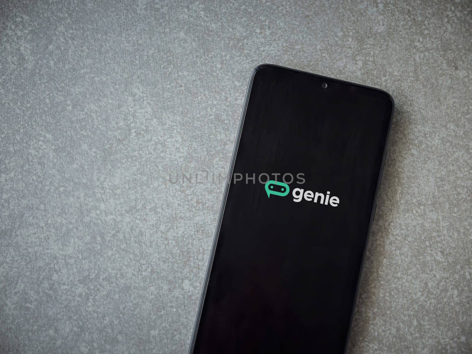 Lod, Israel - July 16,2023: Genie app launch screen on smartphone on ceramic stone background. Top view flat lay with copy space.