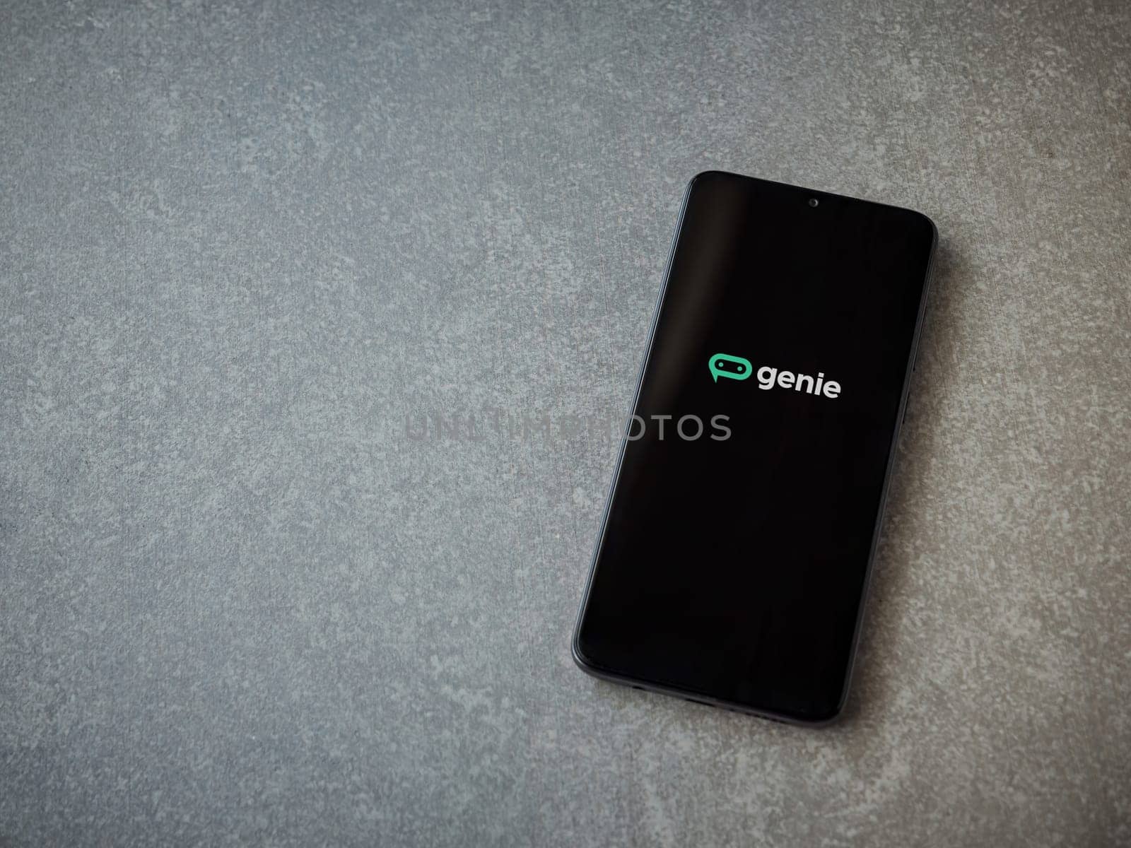 Lod, Israel - July 16,2023: Genie app launch screen on smartphone on ceramic stone background. Top view flat lay with copy space.