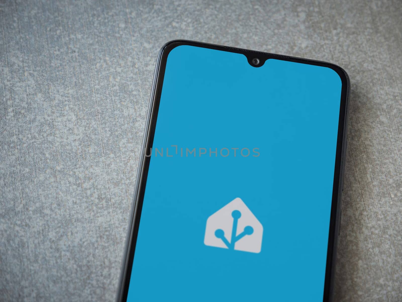 Lod, Israel - July 16,2023: Home Assistant app launch screen on smartphone on ceramic stone background. Top view flat lay with copy space.