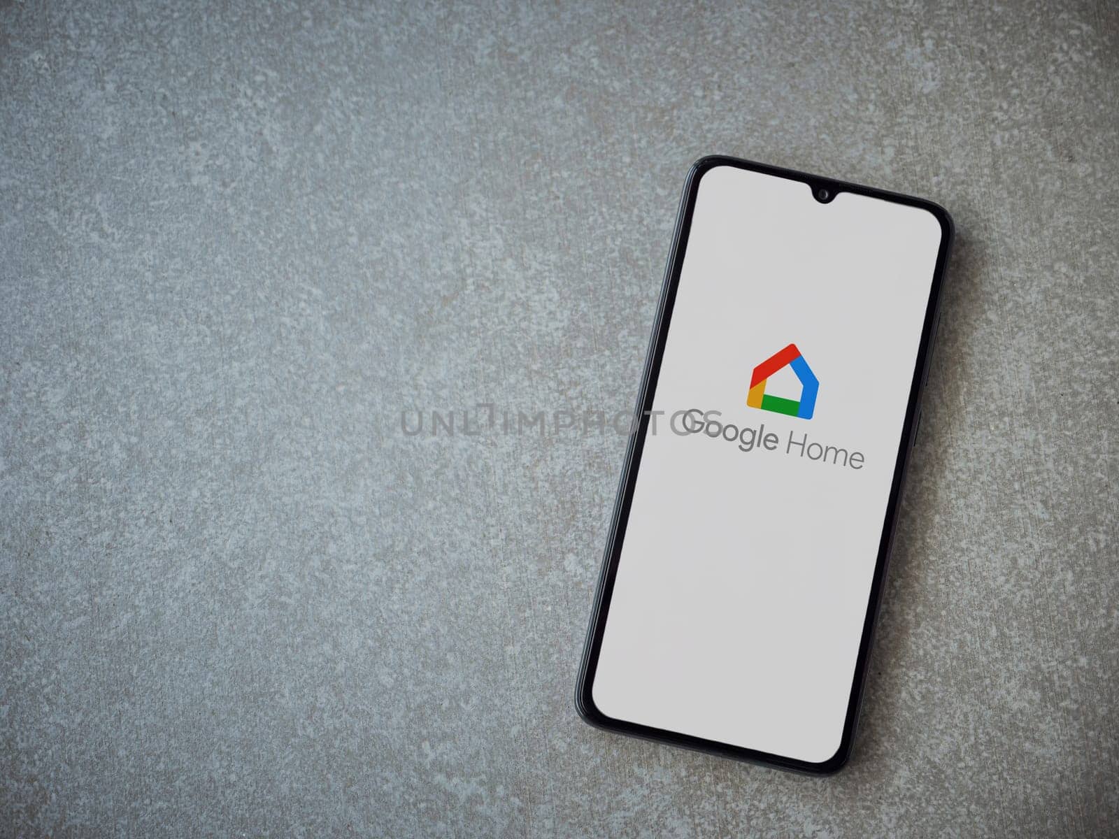 Lod, Israel - July 16,2023: Google Home app launch screen on smartphone on ceramic stone background. Top view flat lay with copy space.
