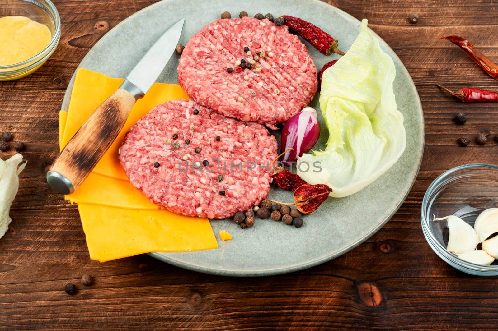 Fresh with seasoning raw minced beef steak burgers. Cooking burger. Raw steak cutlets. Wooden background.