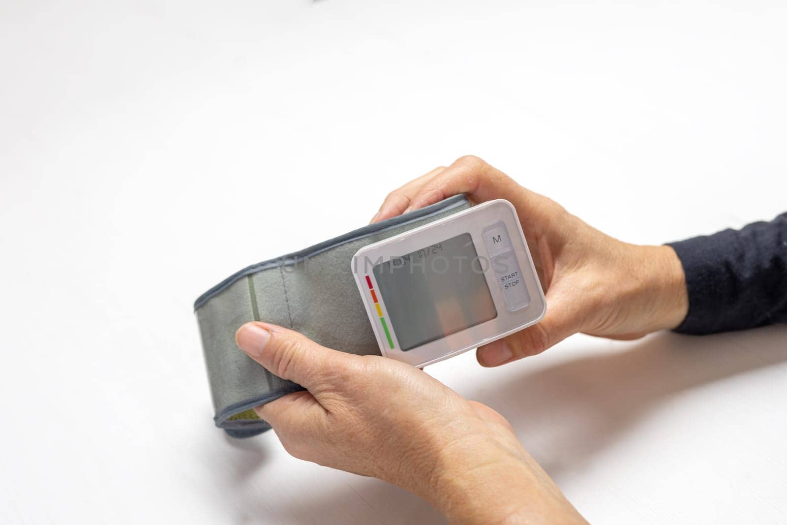 Female hands holding a blood pressure monitor with empty display ready for your text.