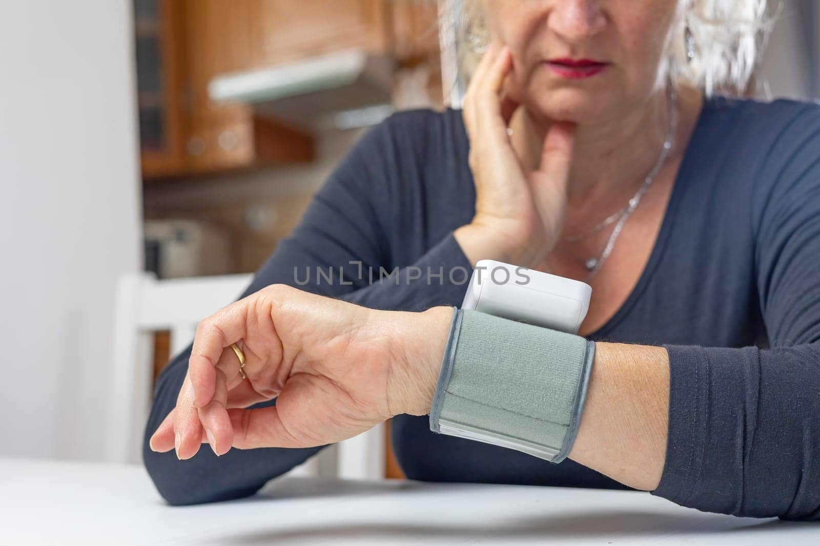 Surprised woman sadly looks at blood pressure measurement results.