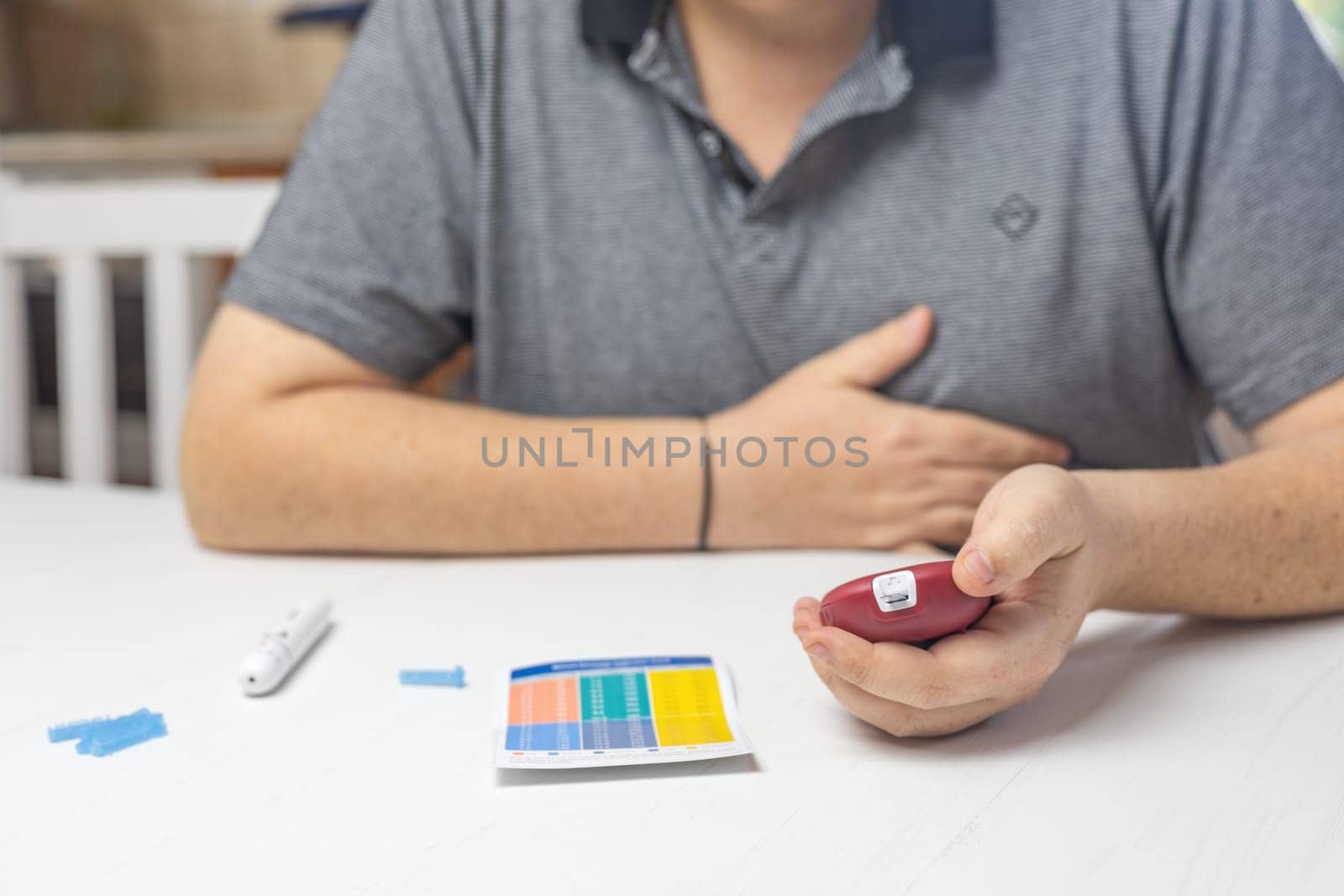 Unpleasantly surprised man looks at the results of blood sugar  level measurement. Horizontally.