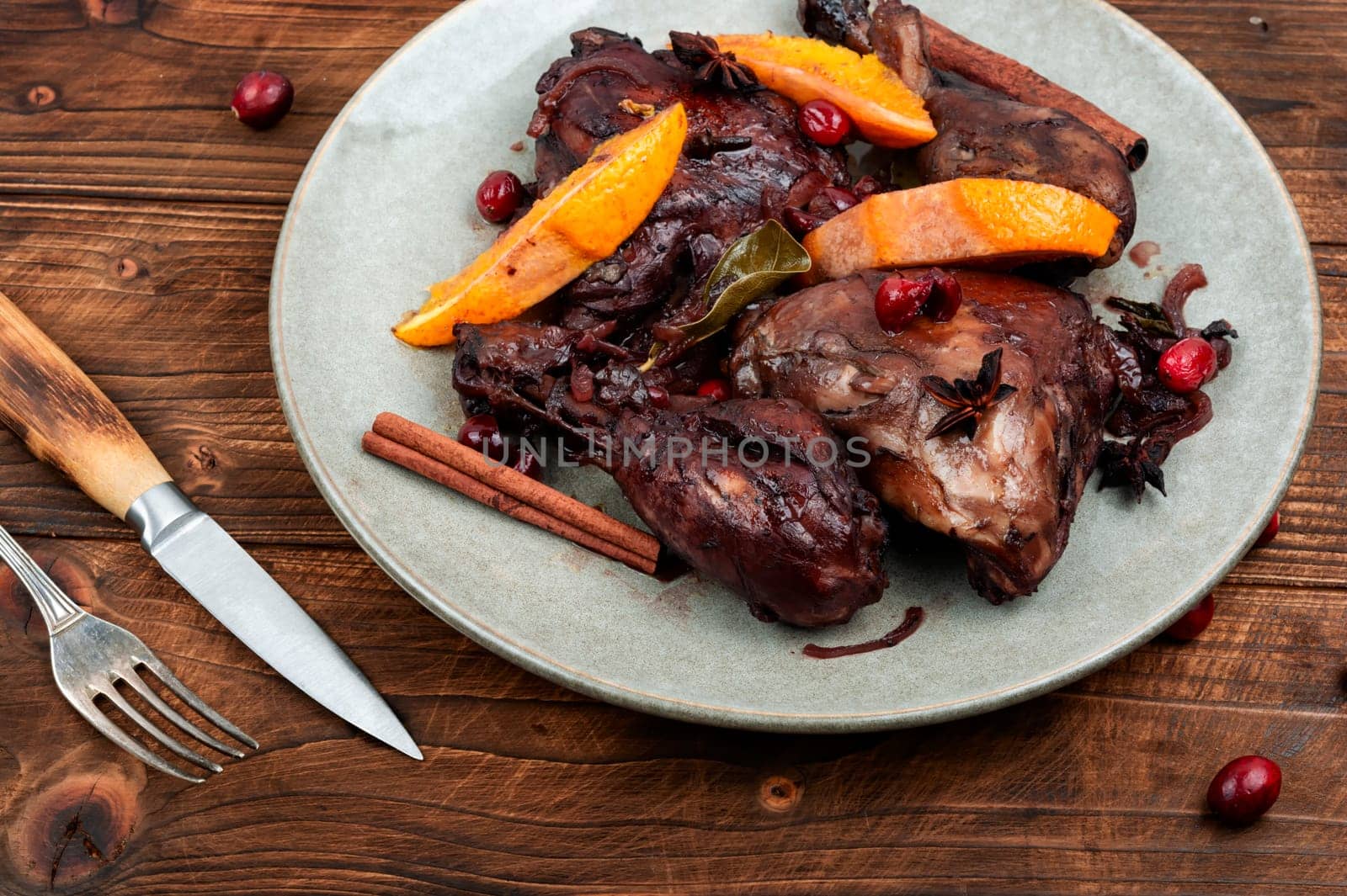 Chicken legs marinated in red wine, baked with orange and berries. Roasted chicken meat. Top view. Copy space.