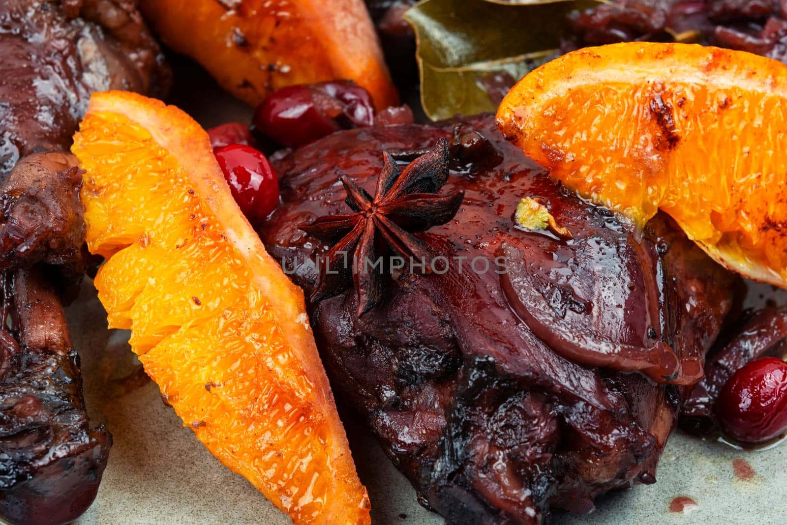 Baked chicken legs with orange and berries.