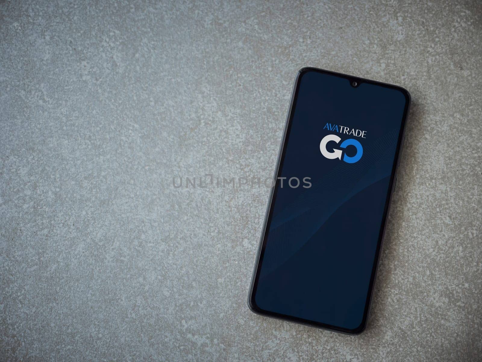 Lod, Israel - July 16,2023: Avatrade app launch screen on smartphone on ceramic stone background. Top view flat lay with copy space.
