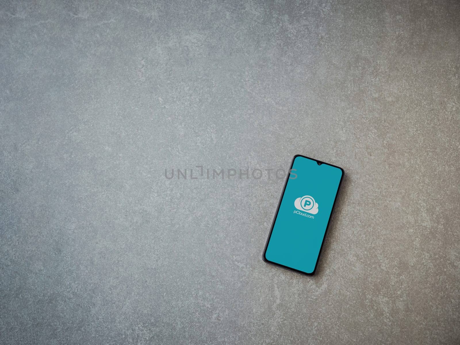 Lod, Israel - July 16,2023: pCloud app launch screen on smartphone on ceramic stone background. Top view flat lay with copy space.