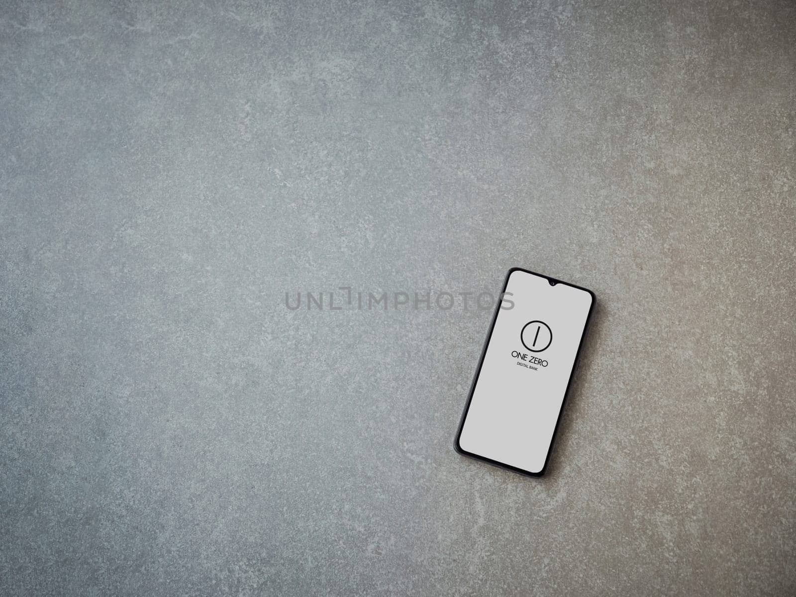 Lod, Israel - July 16,2023: One Zero app launch screen on smartphone on ceramic stone background. Top view flat lay with copy space.