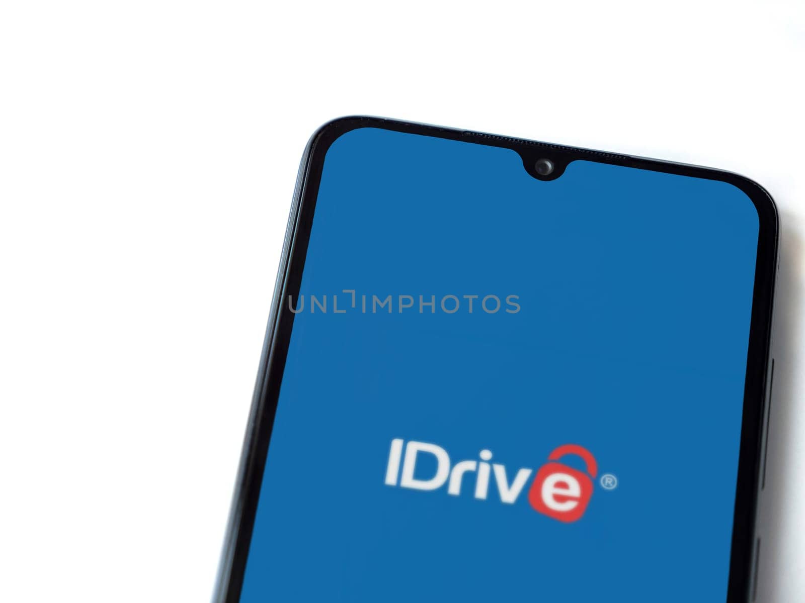 Lod, Israel - July 16,2023: IDrive Online Backup app launch screen on smartphone on white background. Top view flat lay with copy space.