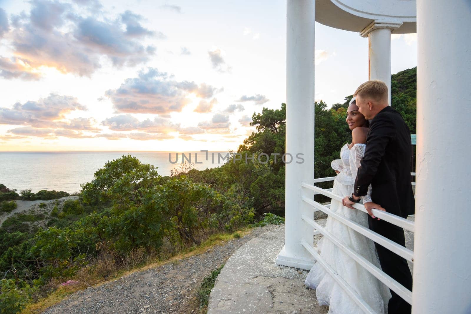 Newlyweds in a gazebo with columns on the seashore