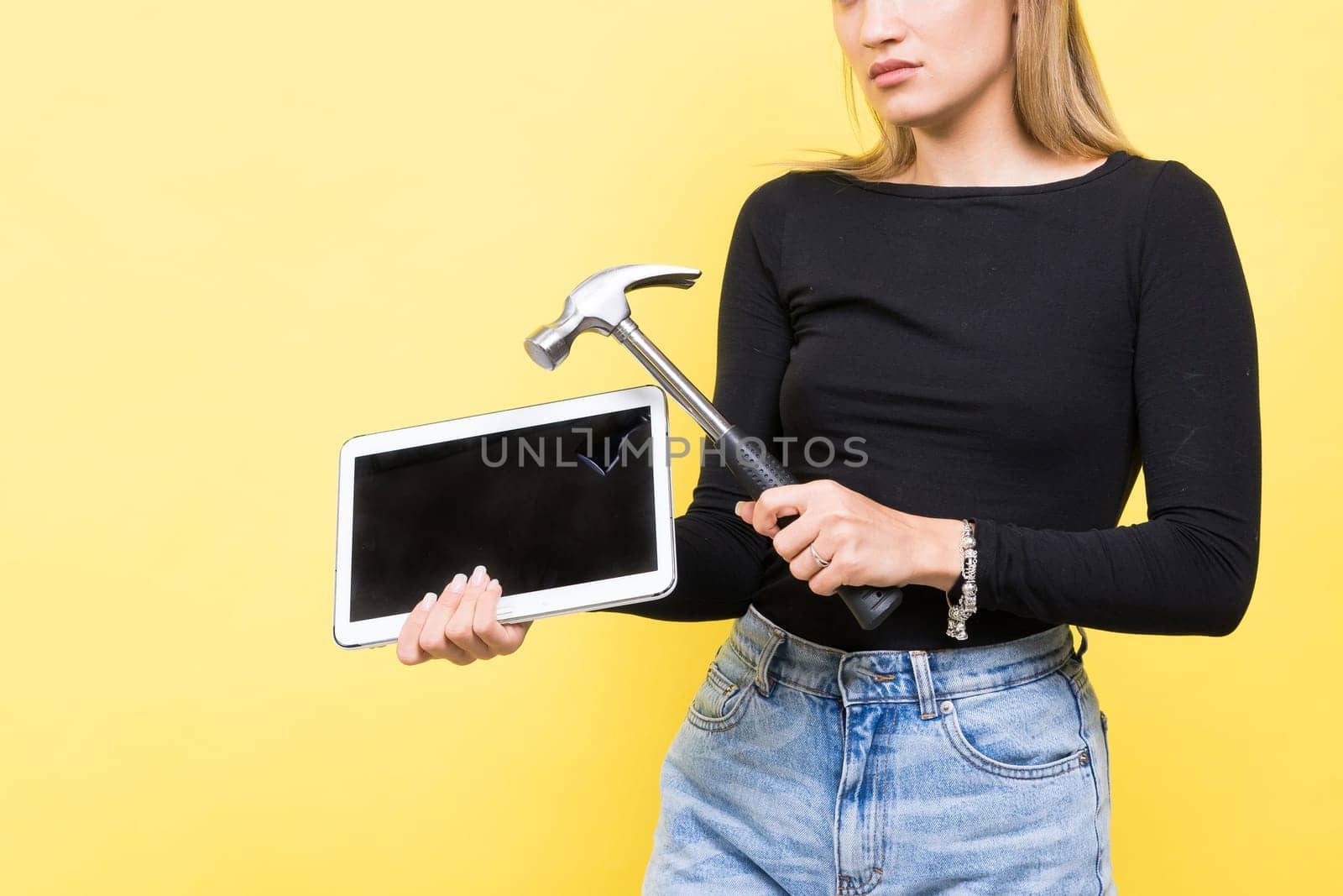 Laptop Repair. Female with hammer and laptop on a yellow background