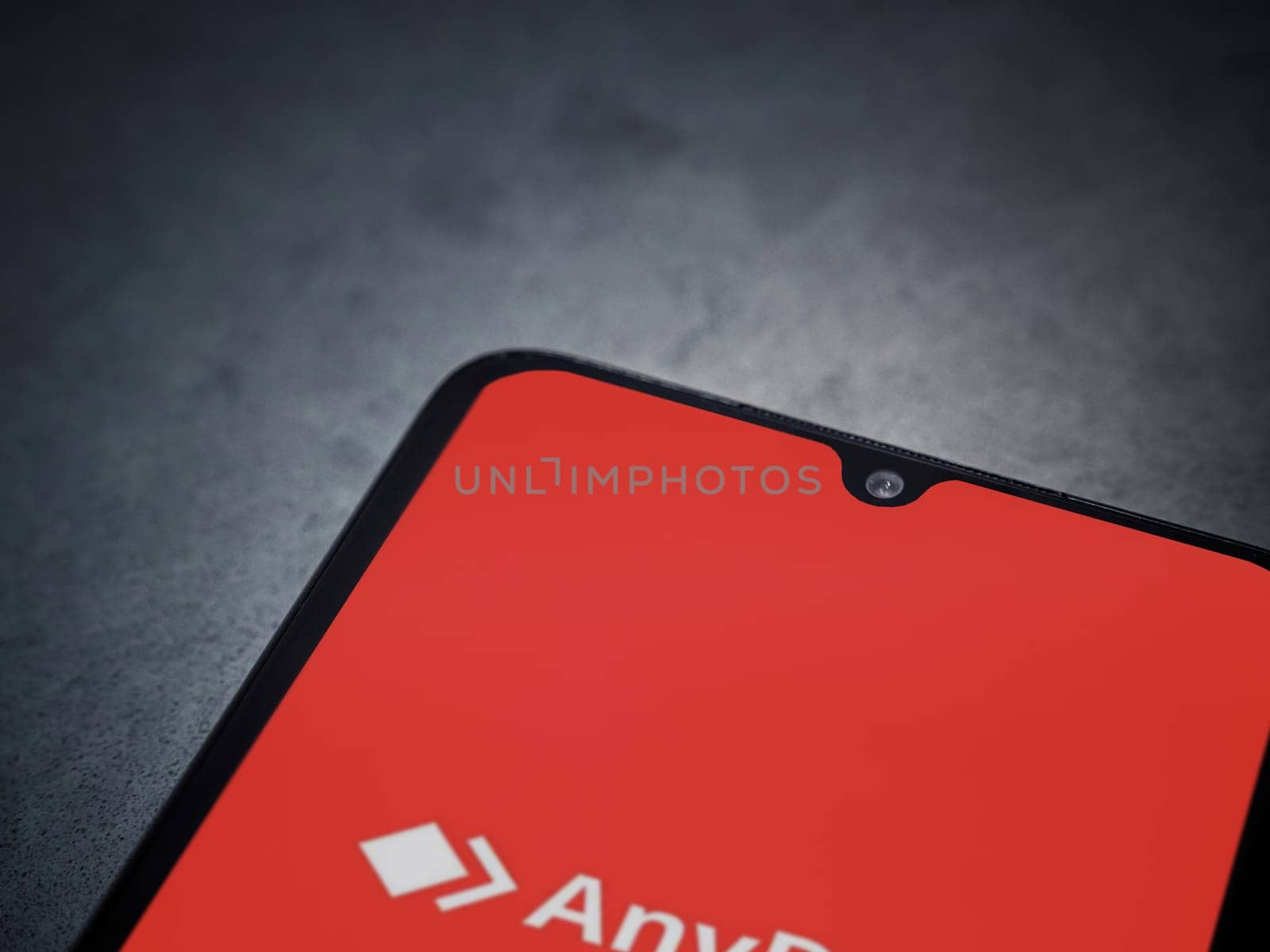 Lod, Israel - July 16,2023: Anydesk app launch screen on smartphone on dark marble stone background. Top view flat lay with copy space.