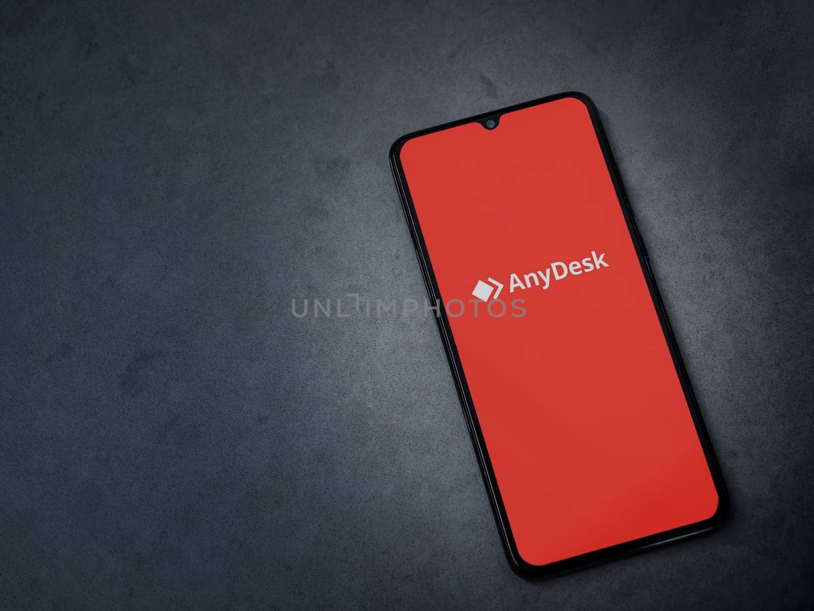 Lod, Israel - July 16,2023: Anydesk app launch screen on smartphone on dark marble stone background. Top view flat lay with copy space.