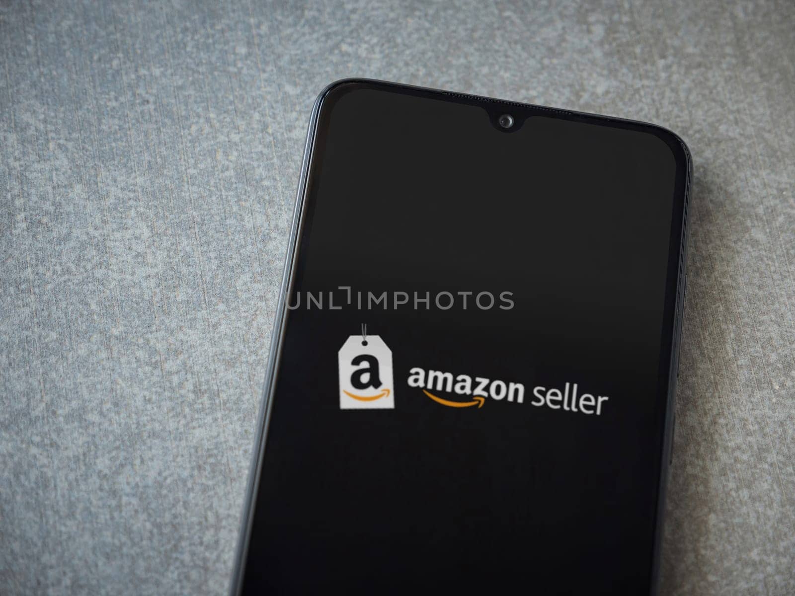 Lod, Israel - July 16,2023: Amazon Seller app launch screen on smartphone on ceramic stone background. Top view flat lay with copy space.