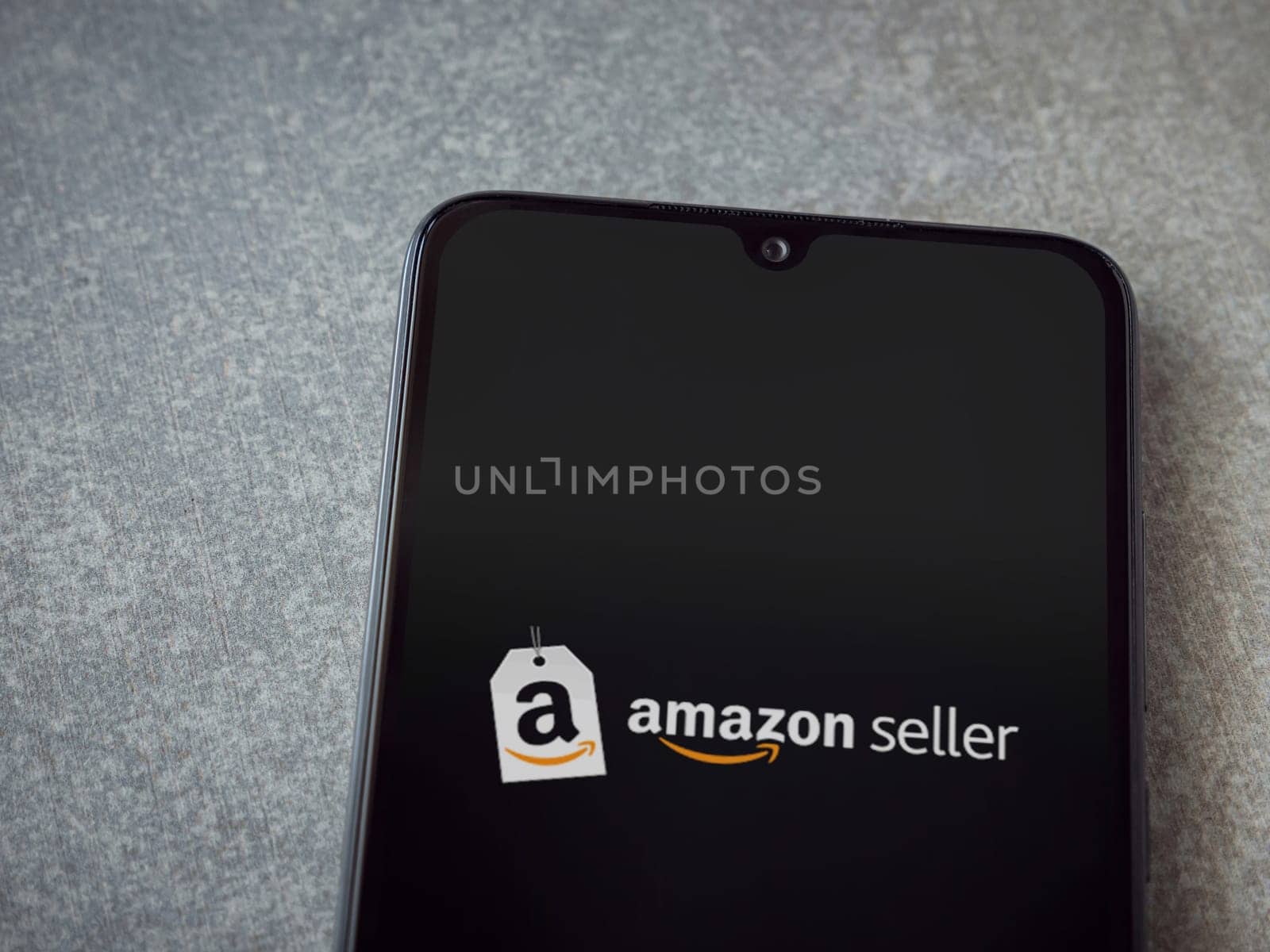 Lod, Israel - July 16,2023: Amazon Seller app launch screen on smartphone on ceramic stone background. Top view flat lay with copy space.