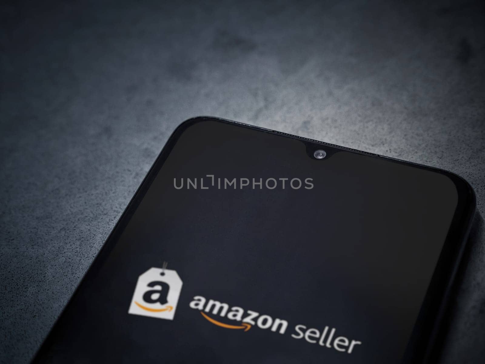 Lod, Israel - July 16,2023: Amazon Seller app launch screen on smartphone on dark marble stone background. Top view flat lay with copy space.