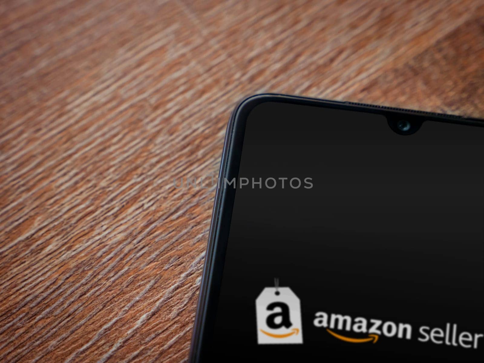 Lod, Israel - July 16,2023: Amazon Seller app launch screen on smartphone on wooden background. Top view flat lay with copy space.