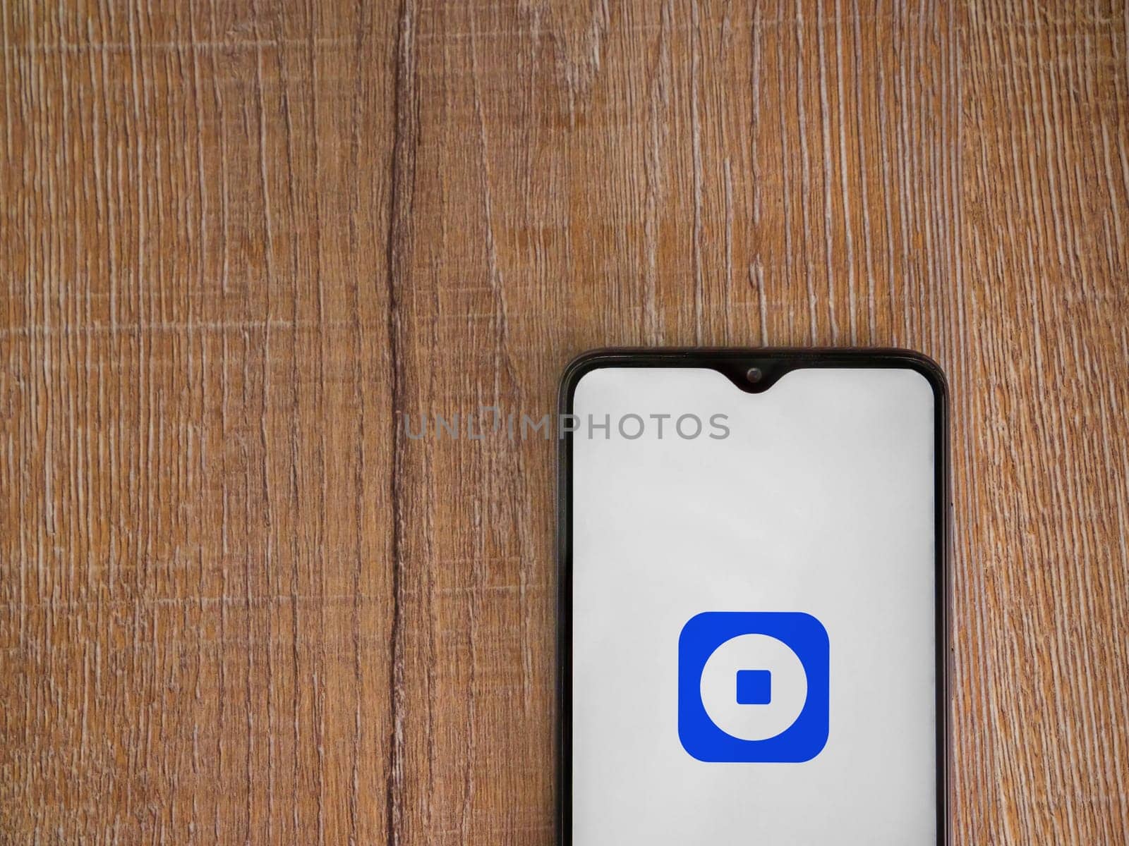 Lod, Israel - July 16,2023: Coinbase Wallet app launch screen on smartphone on wooden background. Top view flat lay with copy space.