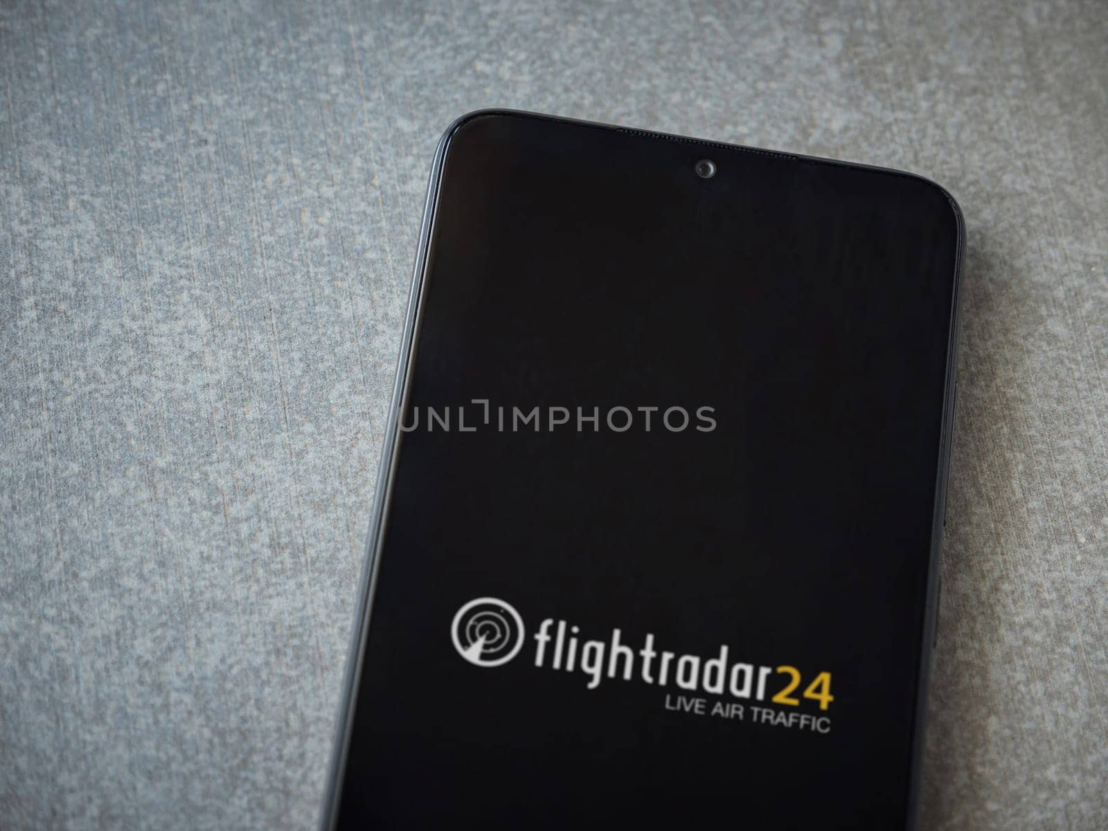 Lod, Israel - July 16,2023: Flightradar24 Flight Tracker app launch screen on smartphone on ceramic stone background. Top view flat lay with copy space.