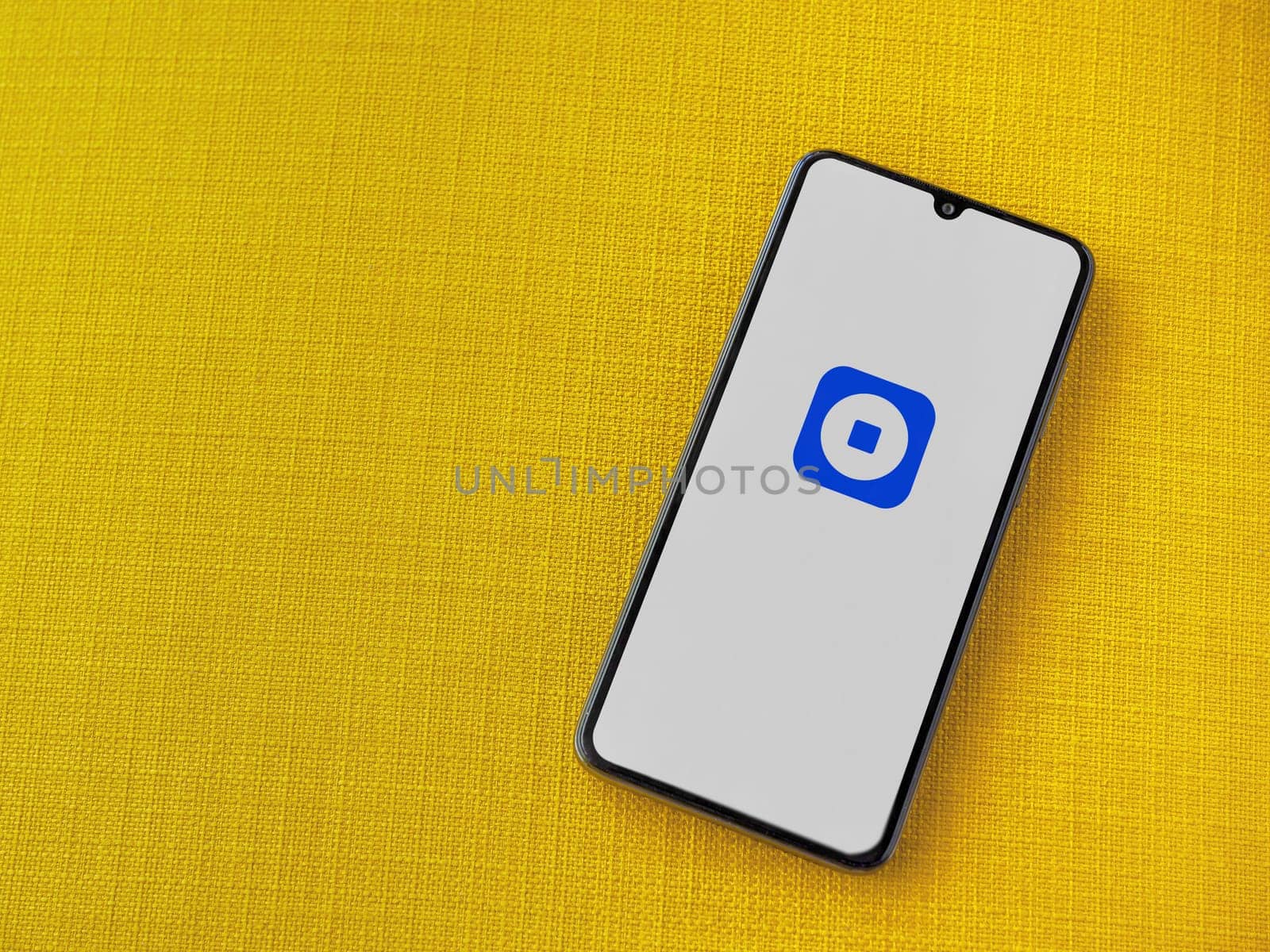 Lod, Israel - July 16,2023: Coinbase Wallet app launch screen on smartphone on yellow fabric background. Top view flat lay with copy space.