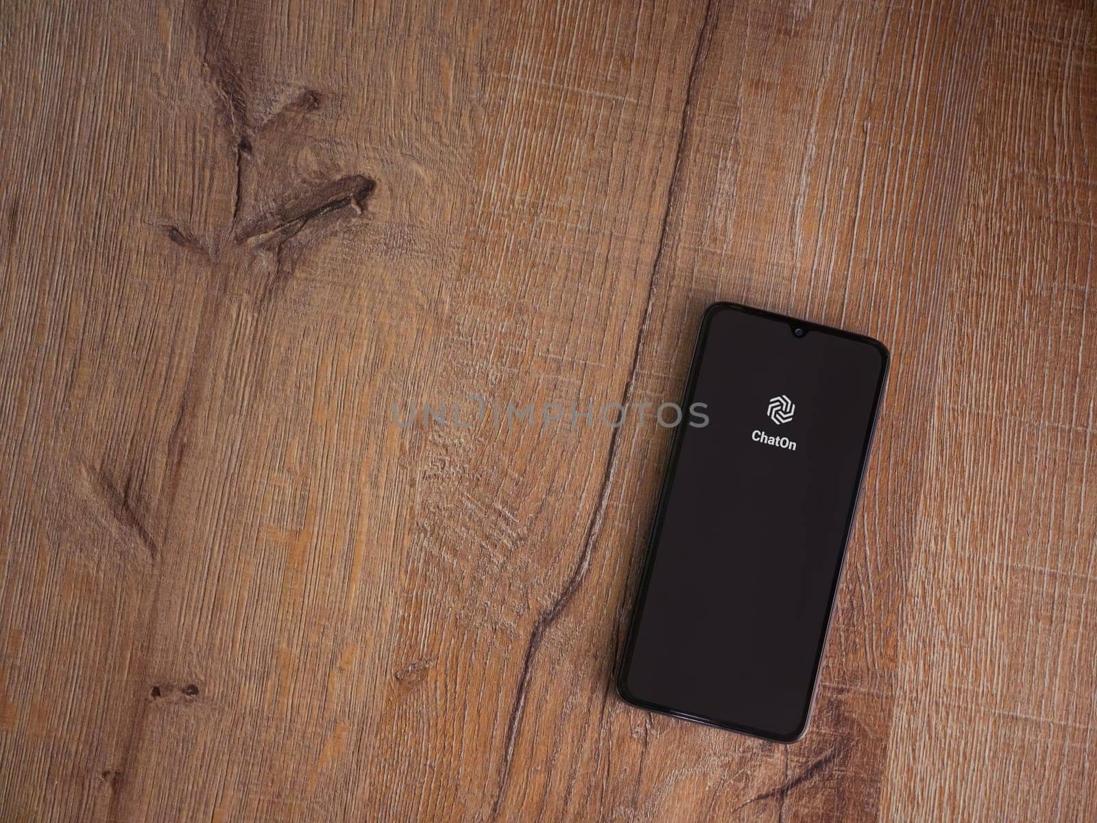 Lod, Israel - July 16,2023: ChatOn app launch screen on smartphone on wooden background. Top view flat lay with copy space.
