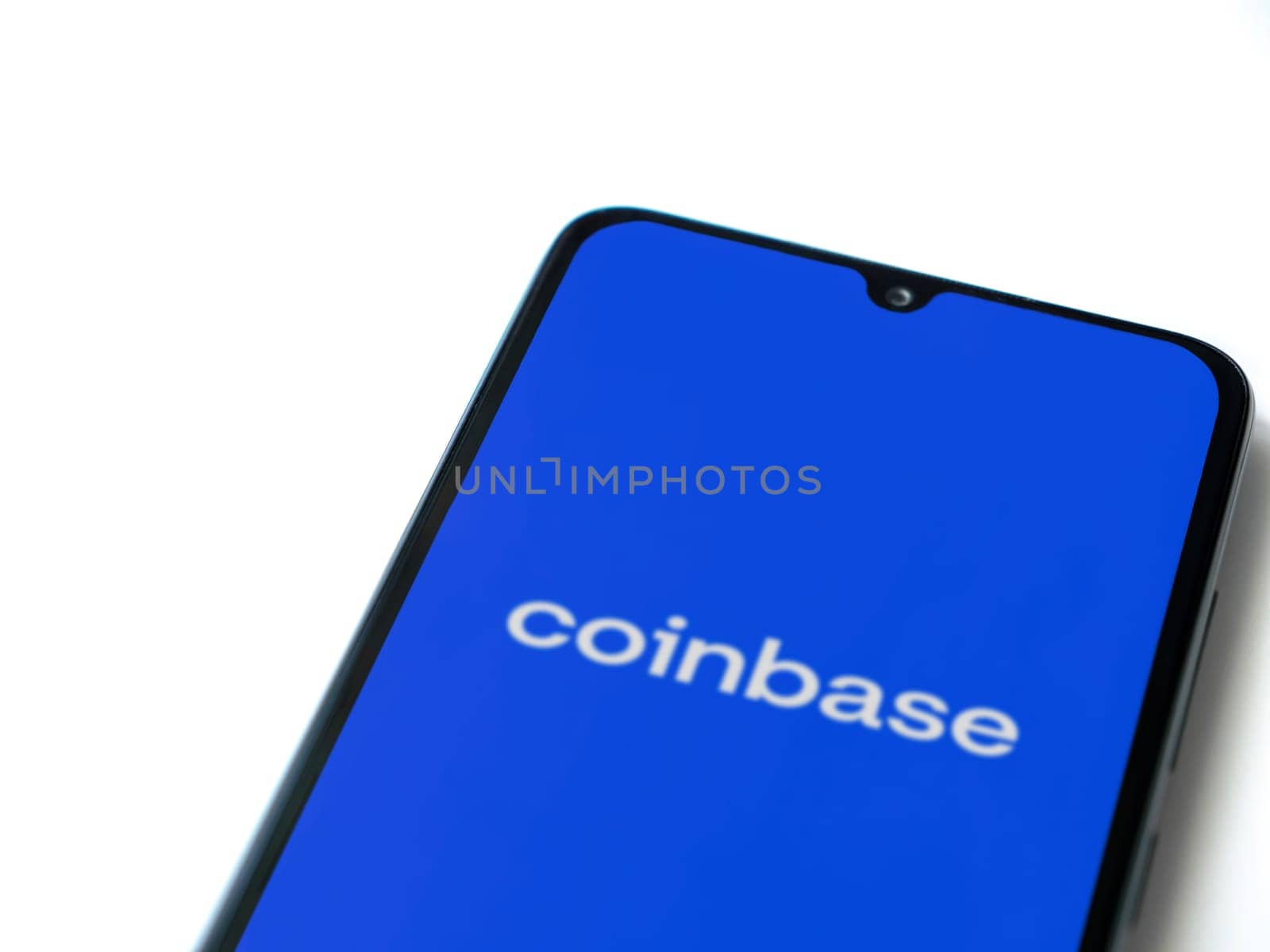 Lod, Israel - July 16,2023: Coinbase app launch screen on smartphone on white background. Top view flat lay with copy space.