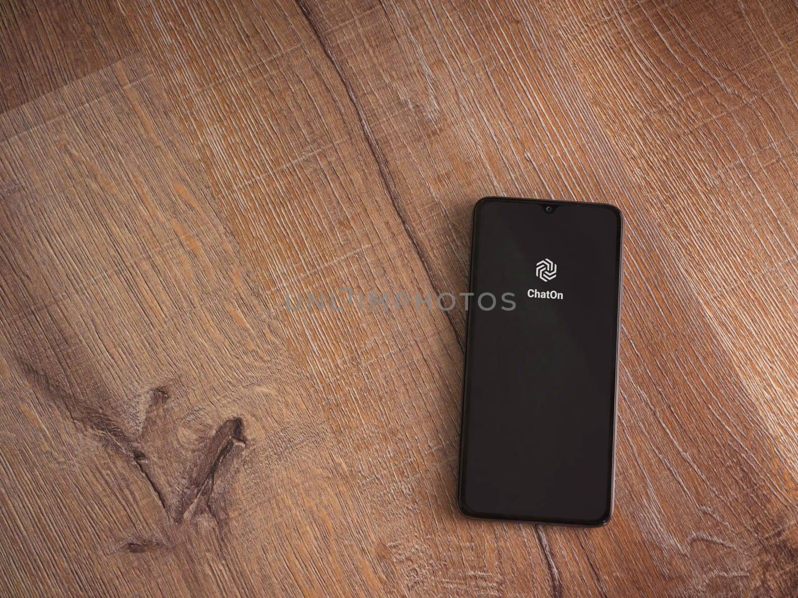 Lod, Israel - July 16,2023: ChatOn app launch screen on smartphone on wooden background. Top view flat lay with copy space.