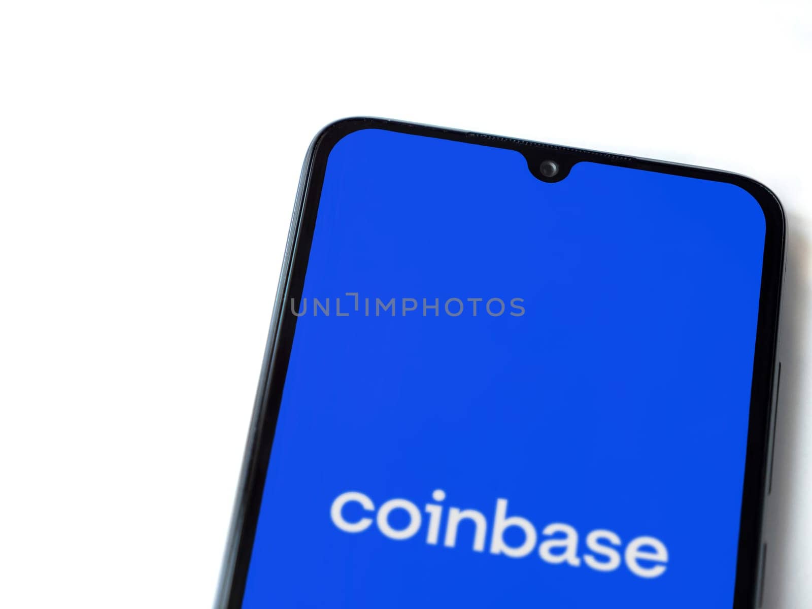 Lod, Israel - July 16,2023: Coinbase app launch screen on smartphone on white background. Top view flat lay with copy space.