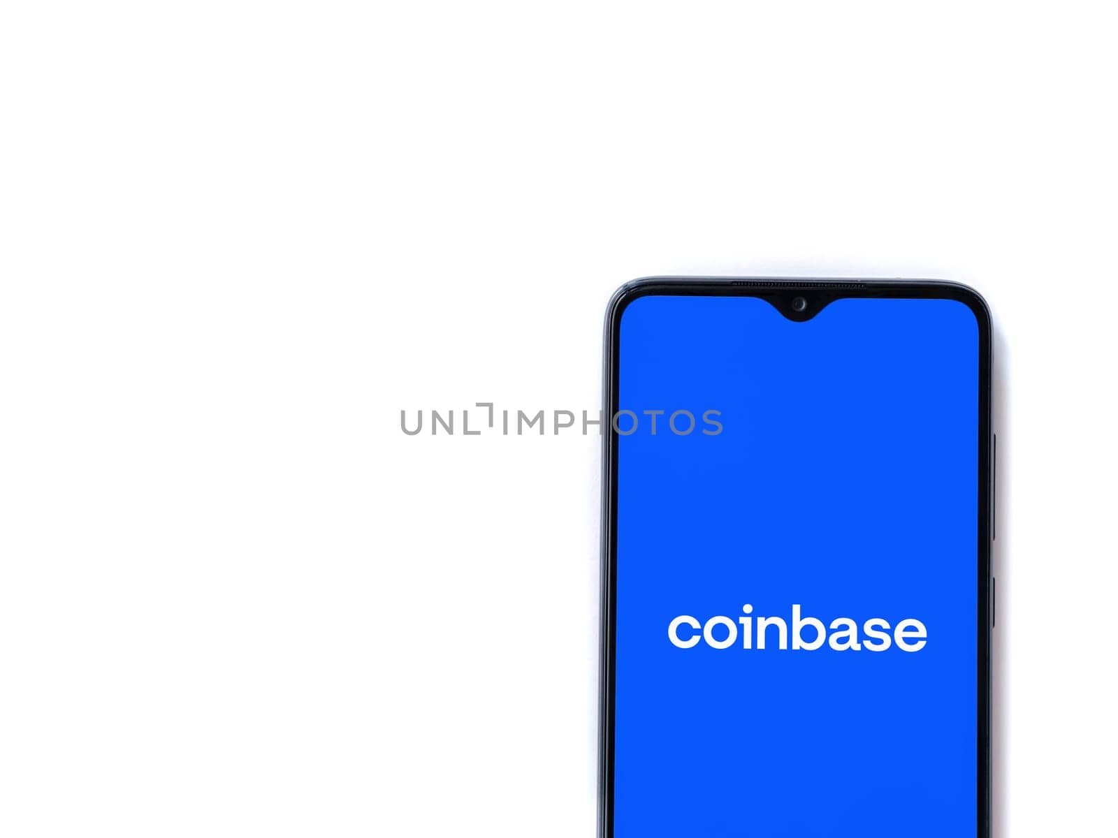 Lod, Israel - July 16,2023: Coinbase app launch screen on smartphone on white background. Top view flat lay with copy space.