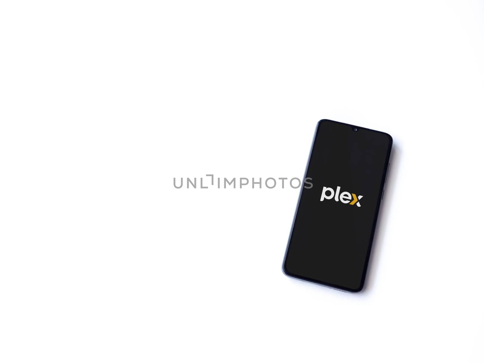 Lod, Israel - July 16,2023: Plex app launch screen on smartphone on white background. Top view flat lay with copy space.