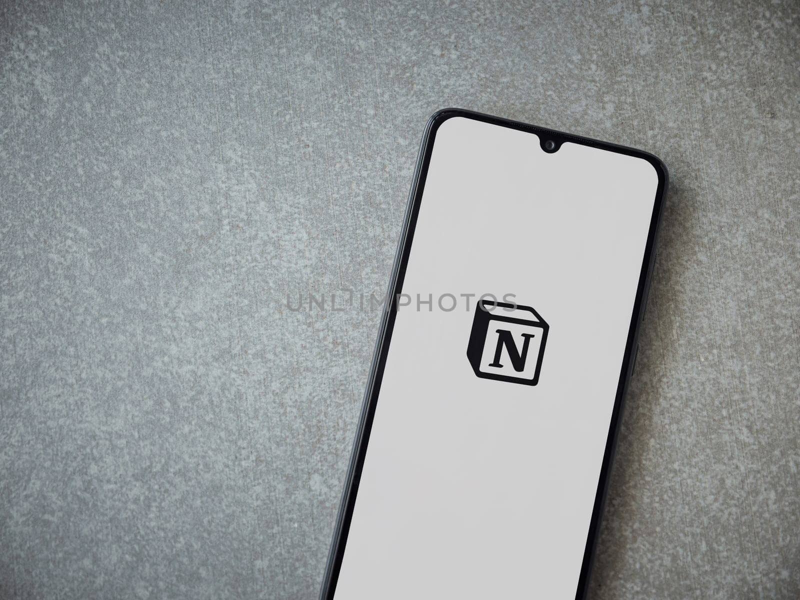 Lod, Israel - July 16,2023: Notion app launch screen on smartphone on ceramic stone background. Top view flat lay with copy space.