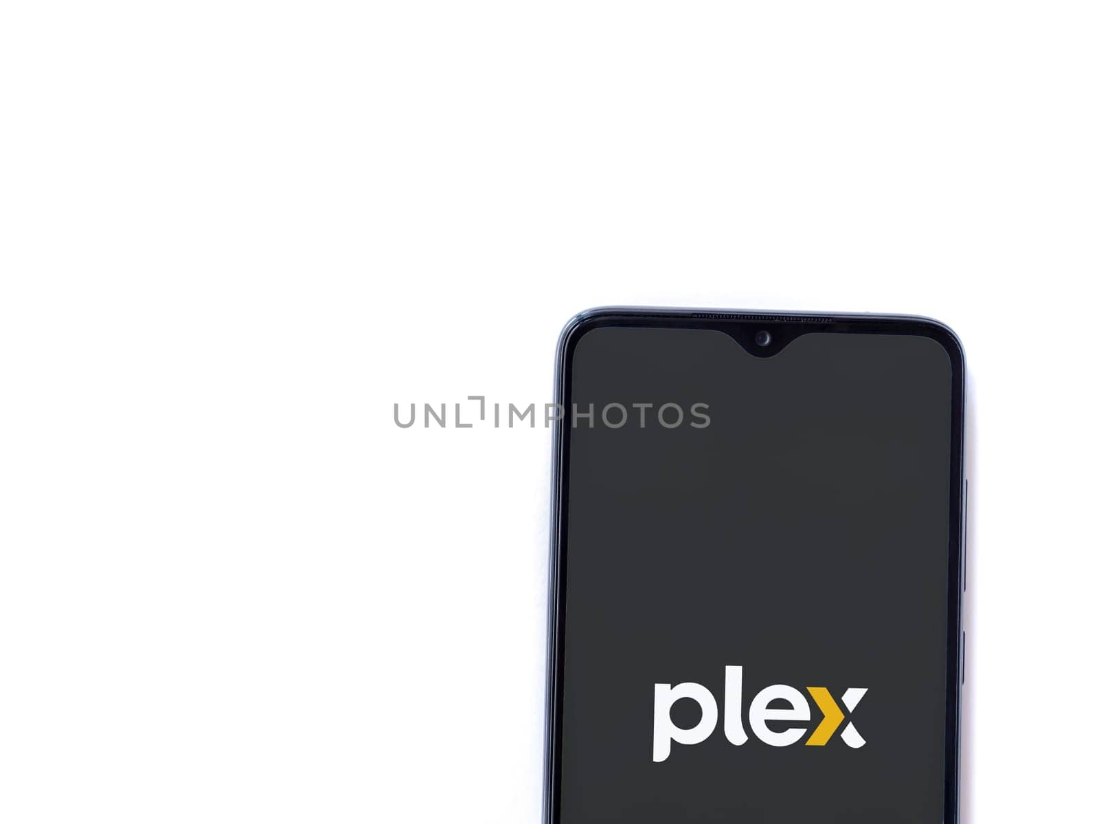 Lod, Israel - July 16,2023: Plex app launch screen on smartphone on white background. Top view flat lay with copy space.
