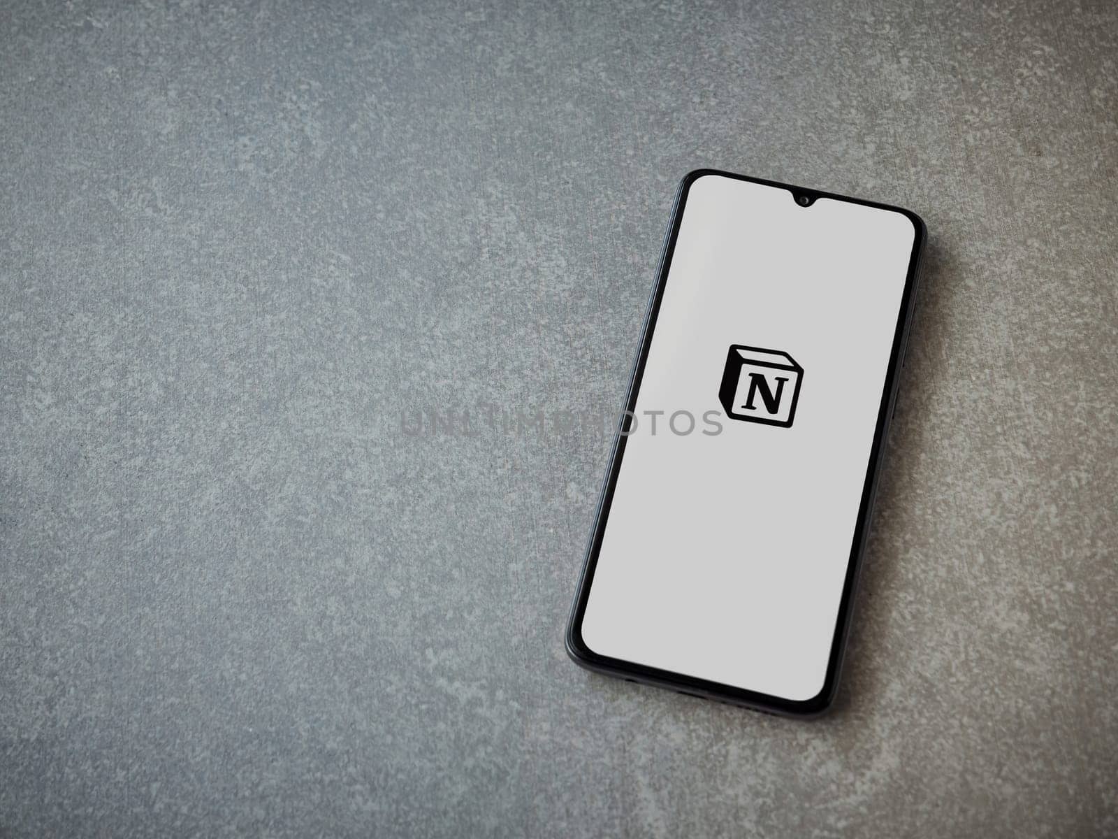 Lod, Israel - July 16,2023: Notion app launch screen on smartphone on ceramic stone background. Top view flat lay with copy space.