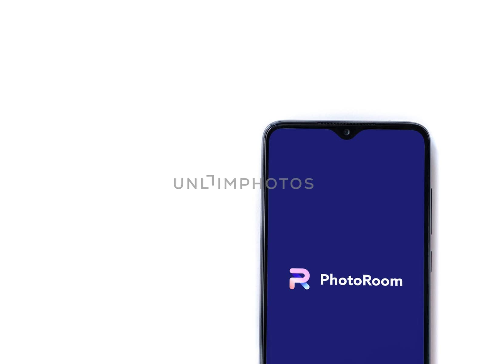 Lod, Israel - July 16,2023: PhotoRoom Studio Photo Editor app launch screen on smartphone on white background.. Top view flat lay with copy space.