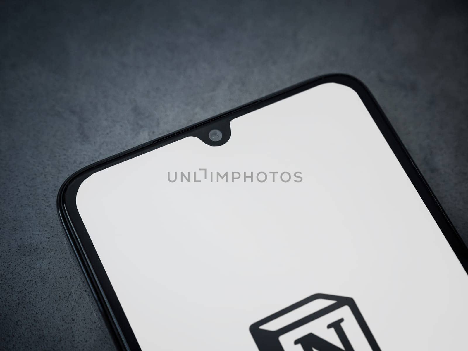 Lod, Israel - July 16,2023: Notion app launch screen on smartphone on dark marble stone background. Top view flat lay with copy space.