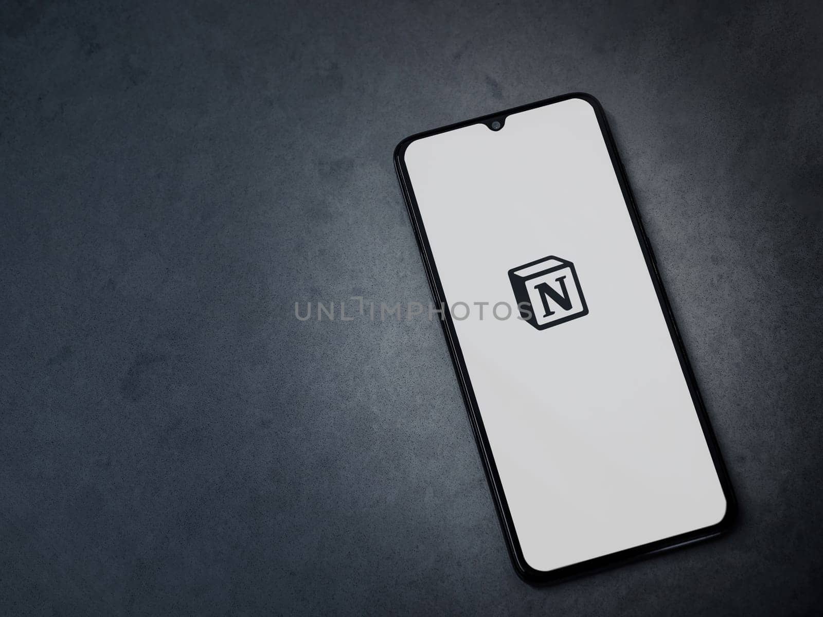 Lod, Israel - July 16,2023: Notion app launch screen on smartphone on dark marble stone background. Top view flat lay with copy space.