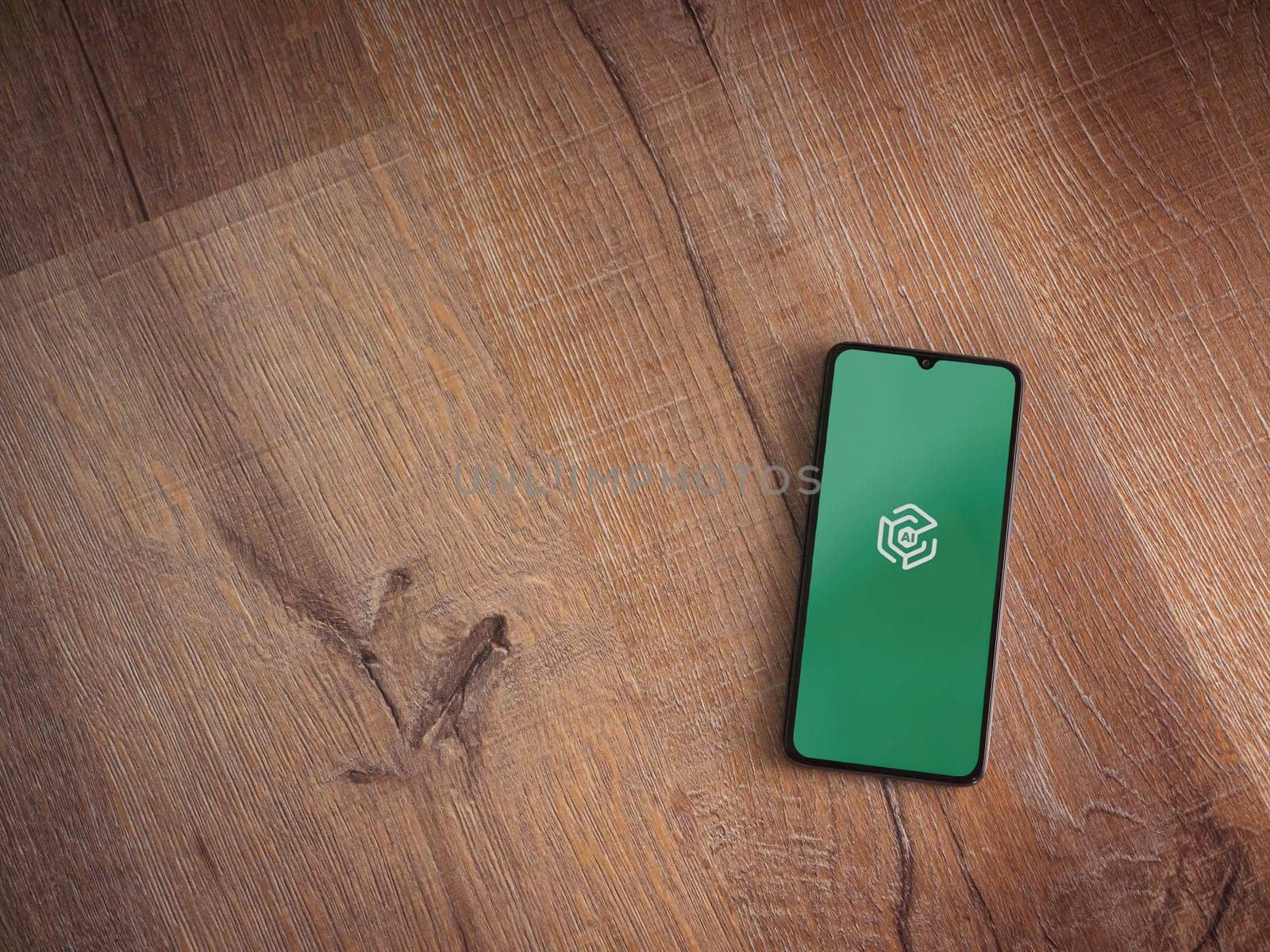 Lod, Israel - July 16,2023: Adam Ai app launch screen on smartphone on wooden background. Top view flat lay with copy space.