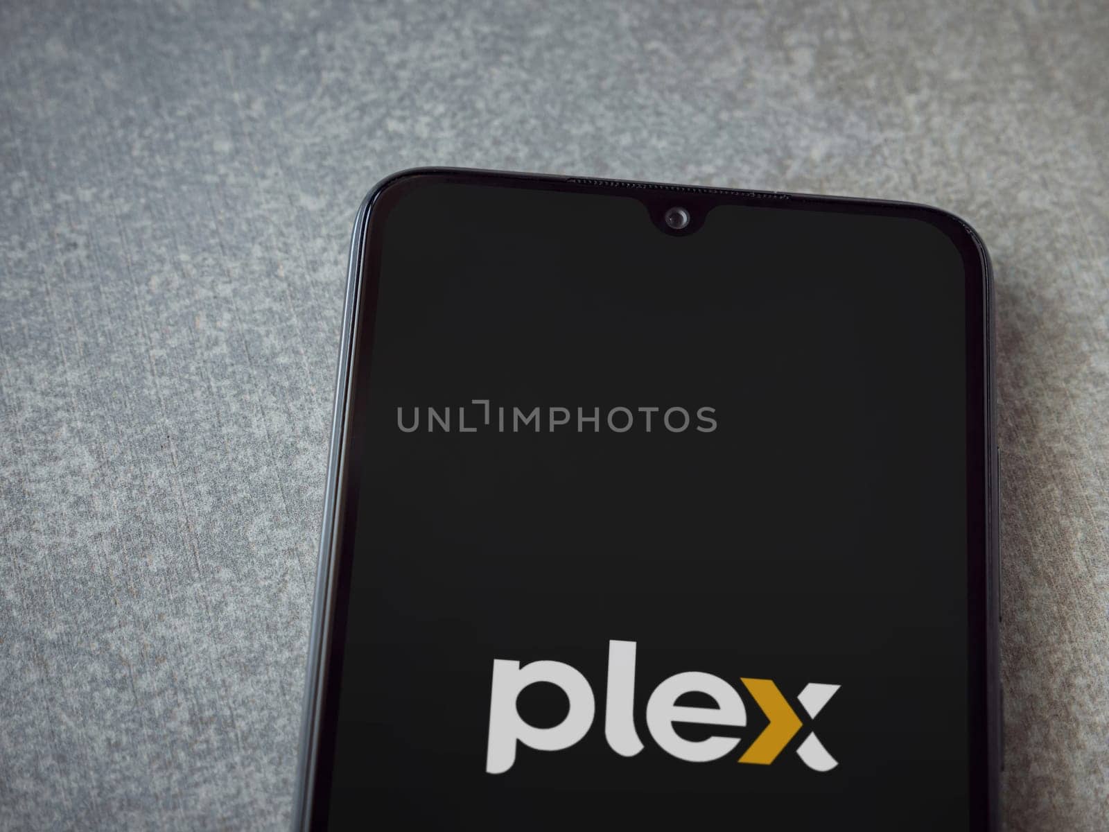 Lod, Israel - July 16,2023: Plex app launch screen on smartphone on ceramic stone background. Top view flat lay with copy space.