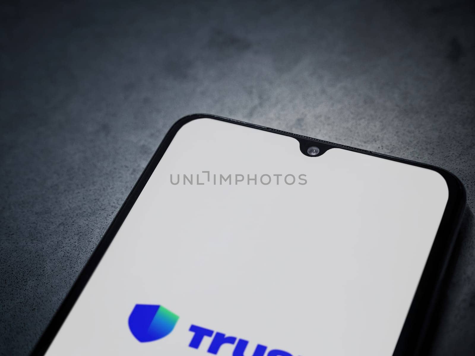 Lod, Israel - July 16,2023: Trust Wallet app launch screen on smartphone on dark marble stone background. Top view flat lay with copy space.