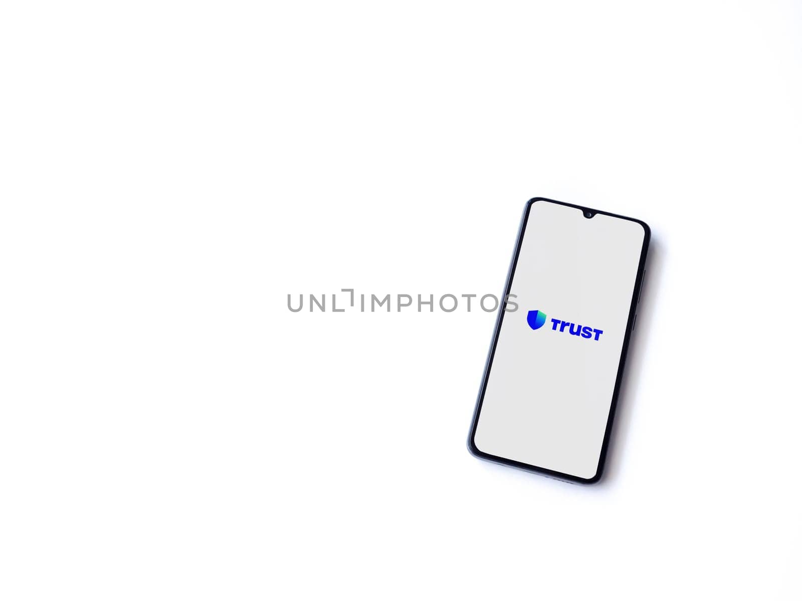 Lod, Israel - July 16,2023: Trust Wallet app launch screen on smartphone on white background. Top view flat lay with copy space.