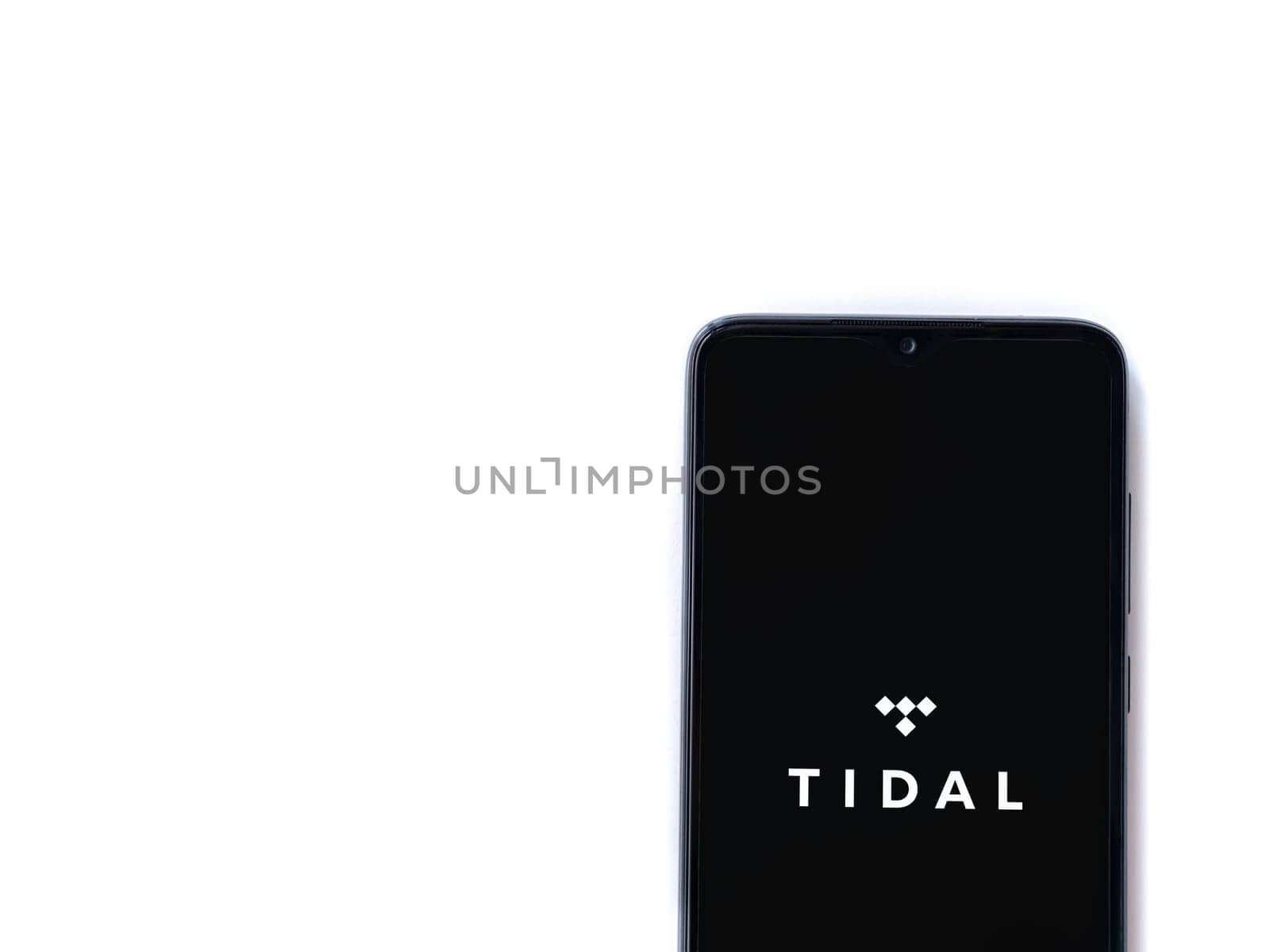 Lod, Israel - July 16,2023: TIDAL Music app launch screen on smartphone on white background. Top view flat lay with copy space.