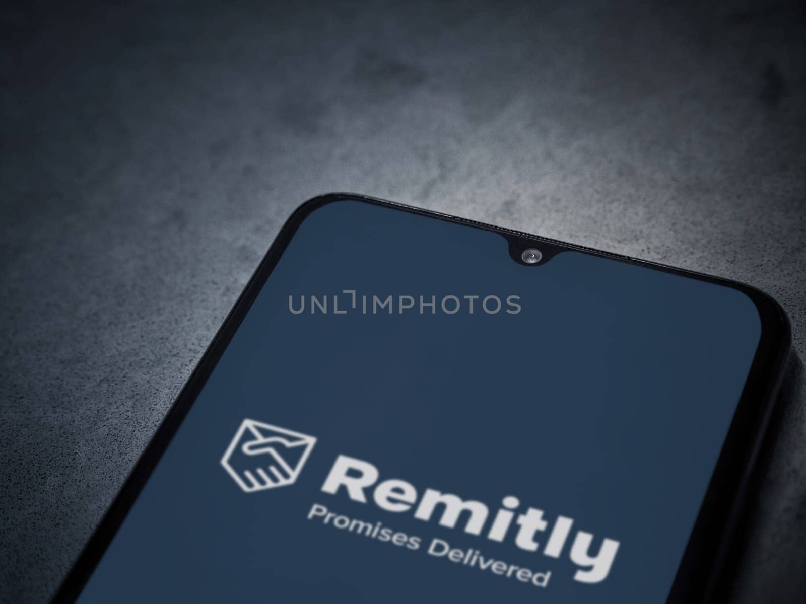 Lod, Israel - July 16,2023: Remitly app launch screen on smartphone on dark marble stone background. Top view flat lay with copy space.