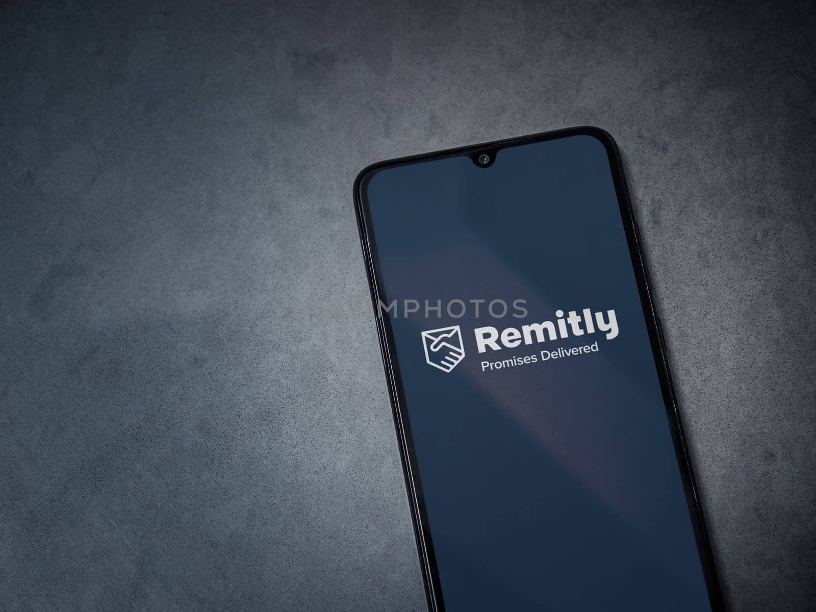 Lod, Israel - July 16,2023: Remitly app launch screen on smartphone on dark marble stone background. Top view flat lay with copy space.