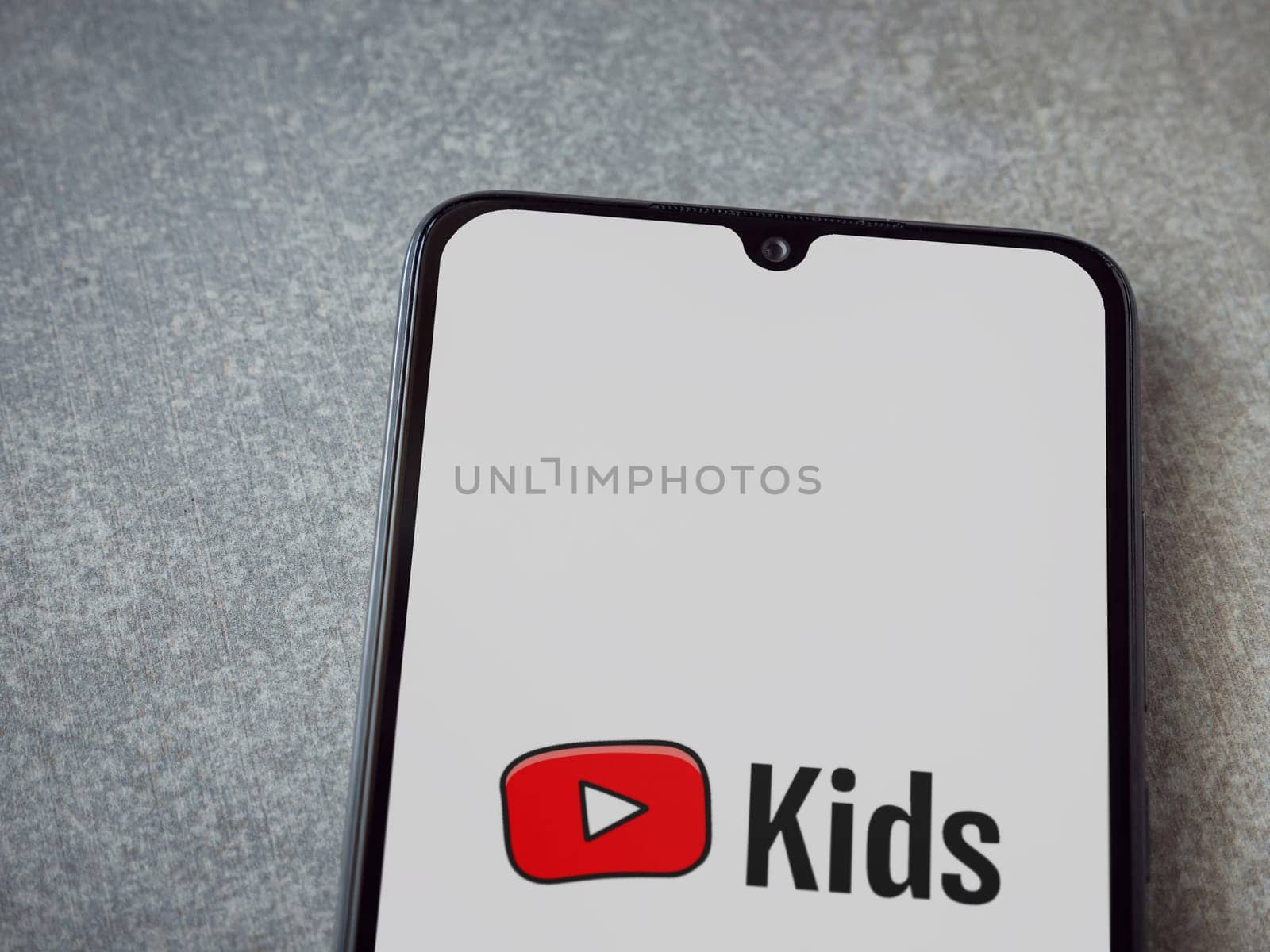 Lod, Israel - July 16,2023: YouTube Kids app launch screen on smartphone on ceramic stone background. Top view flat lay with copy space.