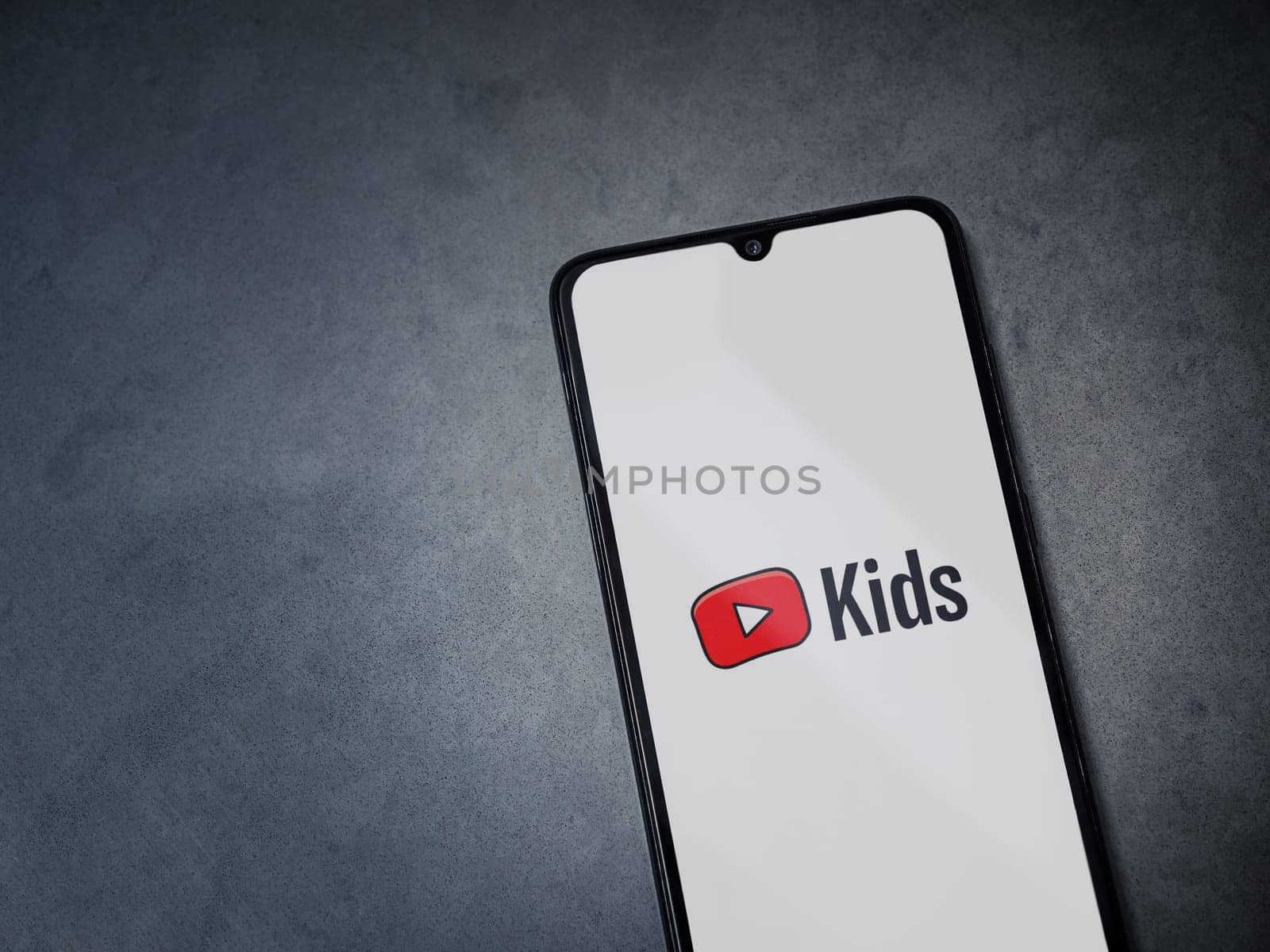 Lod, Israel - July 16,2023: YouTube Kids app launch screen on smartphone on dark marble stone background. Top view flat lay with copy space.