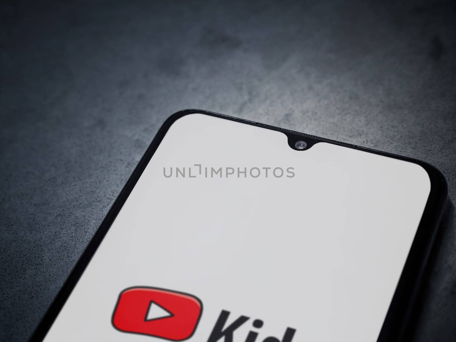 Lod, Israel - July 16,2023: YouTube Kids app launch screen on smartphone on dark marble stone background. Top view flat lay with copy space.